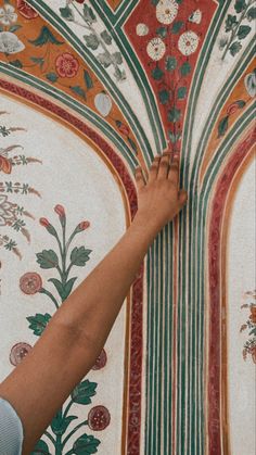 a person reaching up to the ceiling with their hand on it's wallpaper