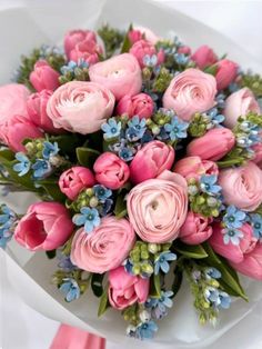 a bouquet of pink flowers sitting on top of a white plate with blue and green leaves