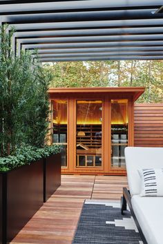 an outdoor living area with a bed, planters and wooden slatted walls