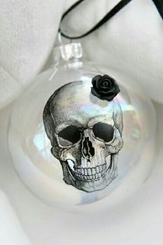 a glass ornament with a skull and a rose on it's side