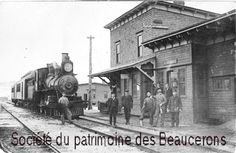 black and white photograph of people standing next to an old train