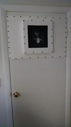 a white door with some black and white pictures on the wall above it's frame