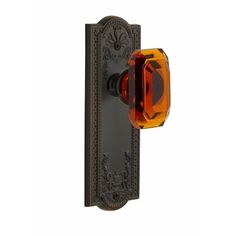 a door handle with an orange glass knob on the front and back side of it