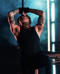 a man with tattoos sitting on a stool