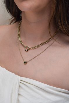 Meet Tia—your new favorite statement piece. With a chunky chain and adorable heart-shaped clasp, this necklace is perfect for adding your favorite charms. It’s the kind of piece that effortlessly adds a fun, stylish twist to any look. Heart clasp chain necklace; charms available for additional purchase 14k gold plated with brass base Protective coating, water resistant 17" chain, 2.5" thick Heart clasp measures approximately 16mm by 15.5mm Fits these clasps: Soleil, Frankie Necklace Charms, 14k Gold Necklace, Gold Collection, Ring Bracelet, Earring Necklace, Chains Necklace, Statement Pieces, Charm Necklace, Necklaces Bracelets