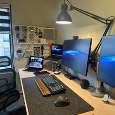 a computer desk with two monitors and a keyboard