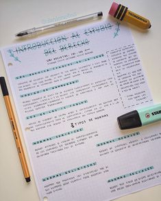 a paper with writing on it next to some markers and pencils, including an eraser