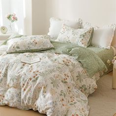 an unmade bed with green and white comforter