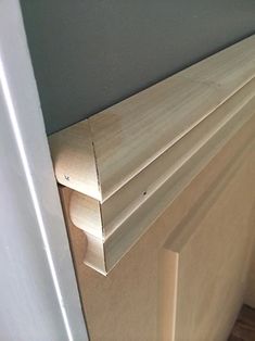 a close up of a wooden door frame on the floor next to a white wall