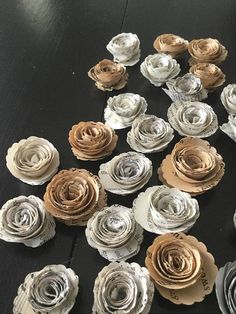 several rolled up paper flowers sitting on top of a wooden table next to each other