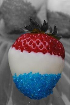 a red, white and blue cake ball with a strawberry on top