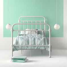 a white metal bed sitting next to a green wall