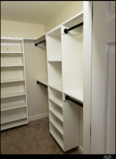 an empty walk in closet with white shelving