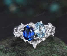 three stone engagement ring set with blue topazte and white diamonds on a rock