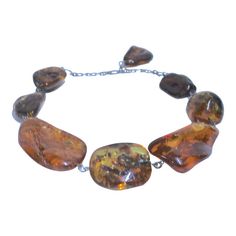 This is part of Chairish’s Fine Jewelry assortment.  The exquisite rare massive ancient natural Baltic "dollop" of fossilized  tree resin, known as Amber, Collar Necklace has several unusual ancient inclusions that have been forever  preserved inside which makes it extremely special.  This example is a fine piece in terms of its huge size, inclusion,  differing colors, clarity and overall aesthetic appeal.   Eight graduated Amber pieces from Huge lighter color to large darker color created in the 20th century into a necklace with sterling contemporary loop connections ending in a 925 sterling chain clasp with a large Amber dangle closure.   It has a beautiful glowing luster shaped with Inclusions and  fissures in the varied coloration and shape of each piece as  a beautiful aged specimen. Standard Oil, Baltic Amber Necklace, Amber Necklace, Vintage Rentals, Baltic Amber, The 20th Century, Collar Necklace, A Necklace, Dark Colors