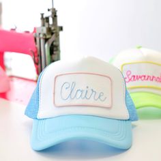 three hats sitting on top of a table next to a sewing machine and thread spool