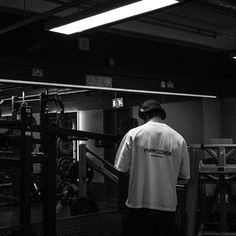 a man in white shirt standing next to metal railing and machine with words on it