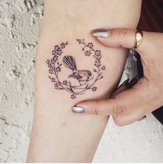 a woman's arm with a bird and flowers tattoo on the left side of her leg