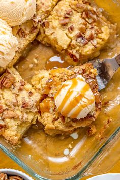 a glass dish filled with ice cream and pecan pie toppings next to two bowls of pecans