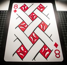 a playing card with red and white designs on it