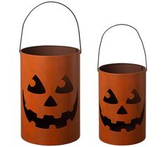 two pumpkin shaped buckets with faces painted on them