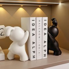 an elephant figurine next to two bookends on top of a shelf