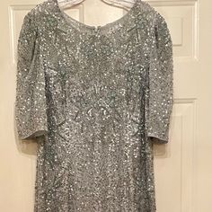 a silver dress hanging on a door with a hanger attached to it's side