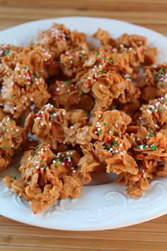 a white plate topped with cookies and sprinkles on top of a wooden table