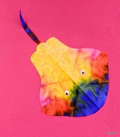 a colorful leaf with two eyes on it is in the middle of a pink background