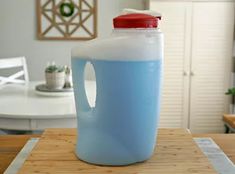 a blue jug sitting on top of a wooden table next to a white dining room chair