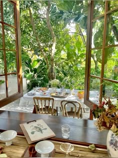 an outdoor dining area with tables, chairs and potted plants in the window sill