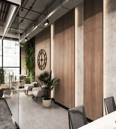 an office with plants on the wall and large windows