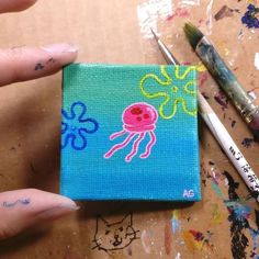 someone is painting an octopus on a piece of canvas with paint and crayons