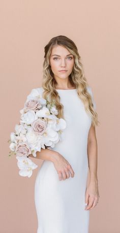 a woman in a white dress holding a bouquet of flowers