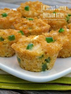 several small muffins on a white plate with green garnishes in them