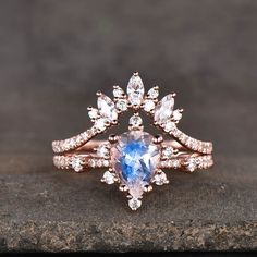 a blue and white ring sitting on top of a stone slab with diamonds around it