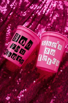 two pink plastic cups sitting on top of a purple sequin tablecloth with the words she's so pretty printed on them