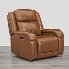 a brown recliner chair sitting on top of a hard wood floor