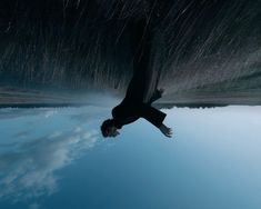 a man is floating in the water with his feet up and arms outstretched to the sky