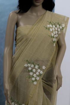 a mannequin wearing a sari with white flowers on it