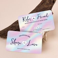 two business cards sitting next to each other on top of a piece of driftwood