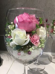 a wine glass filled with flowers on top of a table