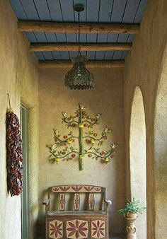 a room with a couch, potted plant and decorative wall hangings on the walls