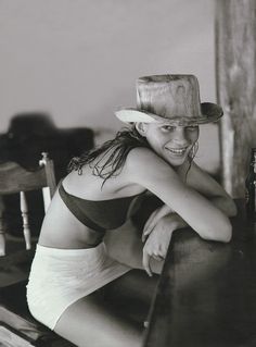 a black and white photo of a woman wearing a cowboy hat