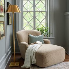 a living room with a chair, lamp and window