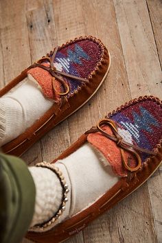 Classic slip-on moccasin slippers featured in a so comfy low-top silhouette with a soft and fluffy Sherpa interior and tied bow details.* Lined interior* Structured sole* Whipstitched details