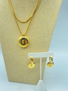 A vintage Liz Claiborne gold tone pendant necklace and charm earrings set from the 90s. This set including a 36 inch gold tone snake chain with a pendant locket and a pair of matching pierced earrings. Each side of the locket and the disk dangle earrings is marked with "XCVI/XCV" on one side and the Liz Claiborne crest on the other. The locket opens. These LCi pierced earrings are in excellent vintage condition as is the snake chain and pendant necklace. All items are signed ©lci. Note: there is Pendant Locket, Chain And Pendant, Vintage Liz Claiborne, Necklace And Earrings Set, Gold Tone Necklace, Wedding Jewelry Sets, Necklace And Earrings, Pierced Earrings, Snake Chain