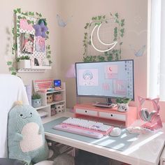 a desk with a computer monitor, keyboard and stuffed animal toy on top of it