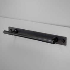 a black door handle on a white wall