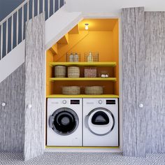 a washer and dryer in a room with stairs leading up to the second floor